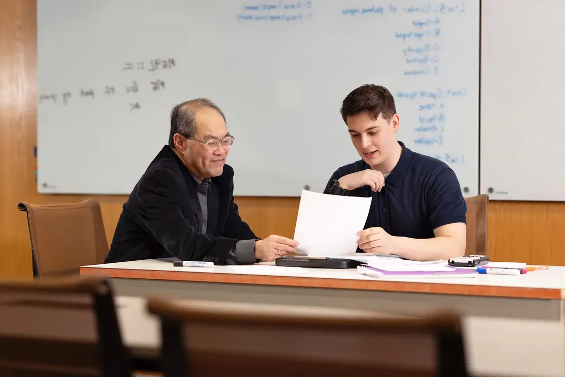 Benjamin Johnson at a table with Professor Shiu Kai Chin.